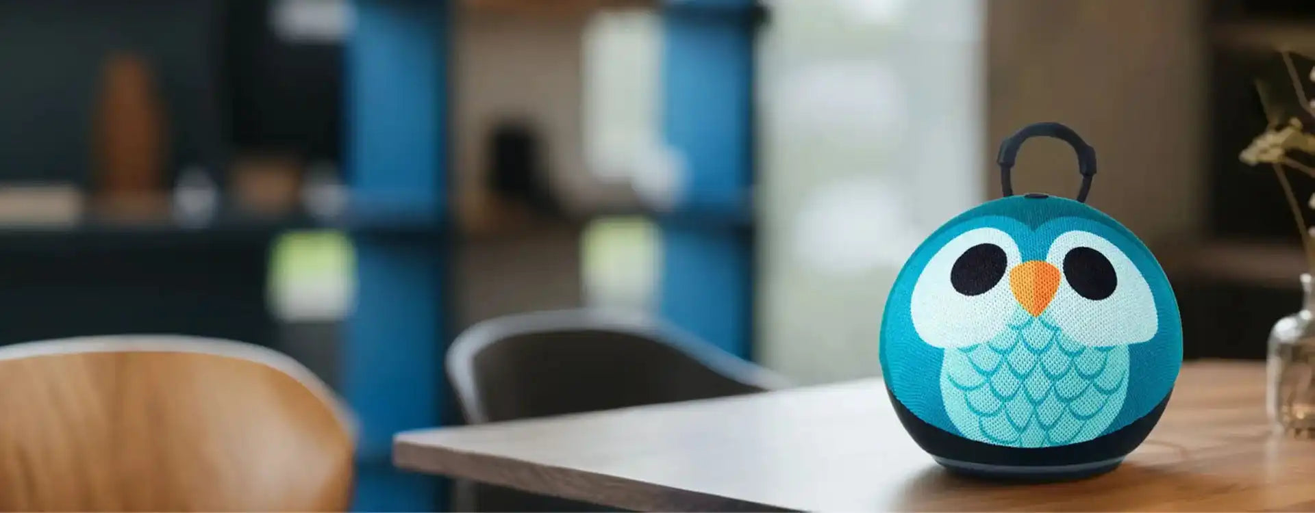 Blue owl-shaped portable speaker with orange beak and eyes, fabric material.slider_item_W3Mf6h