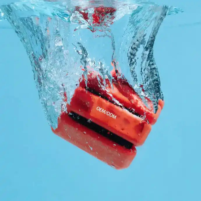 Red waterproof speaker with orange accents and durable plastic design.